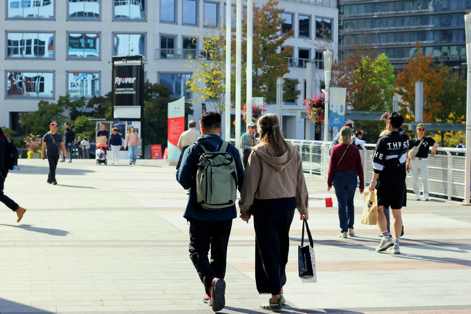 People walking through a busy public plaza in Vancouver on an autumn afternoon